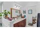 Bathroom with a single sink vanity, large mirror, decorative plants and a shower area at 4738 St Andrews Arc, Leesburg, FL 34748