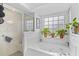 Relaxing bathroom with a soaking tub, glass-enclosed shower, and lush greenery adding a spa-like ambiance at 4738 St Andrews Arc, Leesburg, FL 34748