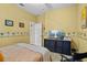 Bedroom with yellow walls, palm tree accents, bed and storage unit with TV at 4738 St Andrews Arc, Leesburg, FL 34748