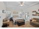 Cozy bedroom features tray ceiling, ensuite bathroom, a comfortable bed, and natural light at 4738 St Andrews Arc, Leesburg, FL 34748