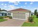 Cozy single-story home with screened-in garage, brick driveway, and attractive landscaping at 4738 St Andrews Arc, Leesburg, FL 34748