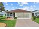 Charming single-story home with a well-manicured lawn, brick driveway, and a lovely screened-in garage at 4738 St Andrews Arc, Leesburg, FL 34748