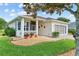 Inviting home exterior with well-kept lawn, brick walkway, and quaint screened-in porch area at 4738 St Andrews Arc, Leesburg, FL 34748