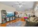 Spacious living room features hardwood floors, a ceiling fan, and flows into the kitchen and dining area at 4738 St Andrews Arc, Leesburg, FL 34748