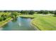 Picturesque pond with a fountain, surrounded by lush green golf course and mature trees at 4738 St Andrews Arc, Leesburg, FL 34748