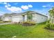 Side view of home exterior, highlighting manicured lawn and landscaping at 5724 Camilla St, St Cloud, FL 34771