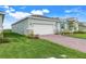 Side angle of the single-story home with a brick driveway, manicured lawn, and inviting curb appeal at 5724 Camilla St, St Cloud, FL 34771