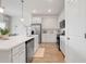 Modern, all-white kitchen featuring stainless steel appliances, a spacious island, and wood-look flooring at 5724 Camilla St, St Cloud, FL 34771
