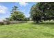 A large back yard with green grass, mature trees, and a wood fence at 7810 Wortham Ct, Orlando, FL 32825
