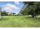 A large back yard with green grass, mature trees, and a wood fence at 7810 Wortham Ct, Orlando, FL 32825