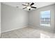 The bedroom has gray walls, neutral tile floor, a window, and a ceiling fan at 7810 Wortham Ct, Orlando, FL 32825