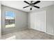 Bedroom features gray walls, neutral tile floor, closet, window, and a ceiling fan at 7810 Wortham Ct, Orlando, FL 32825