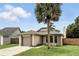 Inviting single-story home with a well-manicured lawn, attached garage, and a large shade tree offering curb appeal at 7810 Wortham Ct, Orlando, FL 32825