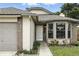 Close up of home's front entrance with a well-maintained walkway, brick accents, and a cozy bay window at 7810 Wortham Ct, Orlando, FL 32825