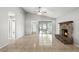 Open-concept living room featuring tile floors, a brick fireplace, and a sliding glass door leading to the enclosed patio at 7810 Wortham Ct, Orlando, FL 32825