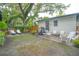 Charming backyard with a stone patio and seating, surrounded by lush greenery and mature trees at 805 E 20Th St, Sanford, FL 32771