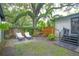 Backyard with mature trees, lounge chairs, and a tranquil seating area at 805 E 20Th St, Sanford, FL 32771