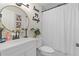 Bright bathroom featuring a modern vanity, round mirror, and tub with shower at 805 E 20Th St, Sanford, FL 32771