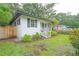Charming white home with black shutters, a quaint porch, and a well-maintained lawn at 805 E 20Th St, Sanford, FL 32771