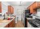 Charming kitchen featuring stainless steel appliances, warm wood cabinets, and a convenient laundry area at 805 E 20Th St, Sanford, FL 32771