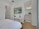 Bright bedroom with TV, leading to an ensuite bathroom, and featuring modern decor and wood-look flooring at 8061 Lost Shaker Ln, Kissimmee, FL 34747