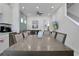 Open-concept dining area featuring a large wooden table, seating for six, and seamless flow into the living room at 8061 Lost Shaker Ln, Kissimmee, FL 34747