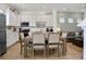 Modern kitchen with white cabinets, quartz countertops, stainless steel appliances, and an adjacent dining area at 8061 Lost Shaker Ln, Kissimmee, FL 34747