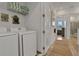 Well-lit laundry room featuring a modern washer and dryer, charming decorations, and convenient storage shelves at 8061 Lost Shaker Ln, Kissimmee, FL 34747