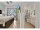Bright main bedroom with ensuite bathroom, wooden floors, balcony access, and a large flat-screen TV at 8061 Lost Shaker Ln, Kissimmee, FL 34747