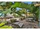 Private outdoor patio area with dining table and lounge chairs surrounded by mature landscaping and tropical foliage at 8061 Lost Shaker Ln, Kissimmee, FL 34747