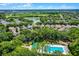 An aerial view of the home in a community with a swimming pool, lake, and manicured greenery at 12524 Aldershot Ln, Windermere, FL 34786