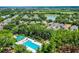 Aerial view of the community swimming pool and surrounding greenery with a view of a lake at 12524 Aldershot Ln, Windermere, FL 34786