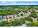 An aerial view shows the home nestled in a lush, green neighborhood with mature trees and landscaping at 12524 Aldershot Ln, Windermere, FL 34786