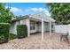 View of the brick-paved back patio with pergola and a manicured green hedge at 12524 Aldershot Ln, Windermere, FL 34786
