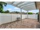 Brick paver patio with a pergola, white fence and patio bench for seating at 12524 Aldershot Ln, Windermere, FL 34786
