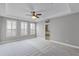 A spacious bedroom with carpet, a ceiling fan, and multiple windows at 12524 Aldershot Ln, Windermere, FL 34786