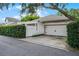 View of home with attached two-car garage, brick-paved patio, and hedge in yard at 12524 Aldershot Ln, Windermere, FL 34786