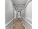 Hallway with arched entryways and wood flooring leading to various rooms at 12524 Aldershot Ln, Windermere, FL 34786