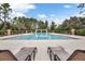 A community pool with lounge chairs under a blue sky with scattered clouds at 12524 Aldershot Ln, Windermere, FL 34786