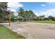 A sand volleyball court surrounded by a green space with trees at 12524 Aldershot Ln, Windermere, FL 34786