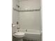Bathroom featuring a white tiled shower with gray accent tiles and modern fixtures at 2075 Dixie Ave, Sanford, FL 32771