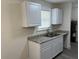 Bright kitchen featuring gray granite countertops and white cabinets complemented by a stainless steel faucet at 2075 Dixie Ave, Sanford, FL 32771
