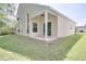 Back of home featuring a covered patio with sliding glass doors and a grassy lawn at 2262 Stonehedge Loop, Kissimmee, FL 34743