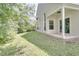 Side view of home featuring a covered patio, large windows, and a spacious lawn at 2262 Stonehedge Loop, Kissimmee, FL 34743