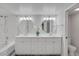 Bathroom featuring a double vanity with granite countertops, and a tub with marble-look shower walls at 2262 Stonehedge Loop, Kissimmee, FL 34743