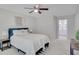 Bright bedroom with a queen-sized bed, ceiling fan, and neutral decor, leading to the en-suite bathroom at 2262 Stonehedge Loop, Kissimmee, FL 34743