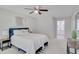 Bright bedroom with a queen-sized bed, ceiling fan, and neutral decor, leading to the en-suite bathroom at 2262 Stonehedge Loop, Kissimmee, FL 34743