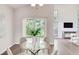 Bright dining area features a glass table and a sliding glass door, adjacent to a large living space at 2262 Stonehedge Loop, Kissimmee, FL 34743