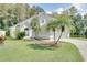 Beautifully landscaped single-Gathering home with healthy lawn, mature palm trees, and attached two-car garage at 2262 Stonehedge Loop, Kissimmee, FL 34743
