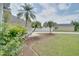 Landscaped front yard with healthy green grass and tropical palm trees adds curb appeal to this charming home at 2262 Stonehedge Loop, Kissimmee, FL 34743